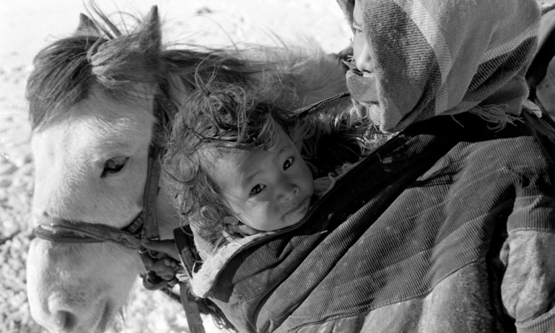 1990年3月，西藏當(dāng)雄縣納木湖鄉(xiāng)三村女牧民斯卓不畏嚴(yán)寒，懷抱幼子，準(zhǔn)備到遠(yuǎn)處放牧。新華社記者覺果攝
