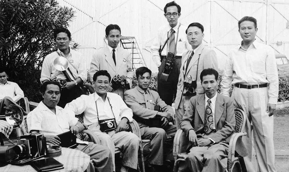 新華社記者錢嗣杰（站立者右二）在采訪會(huì)議開幕式后和外國記者在會(huì)場(chǎng)外休息。