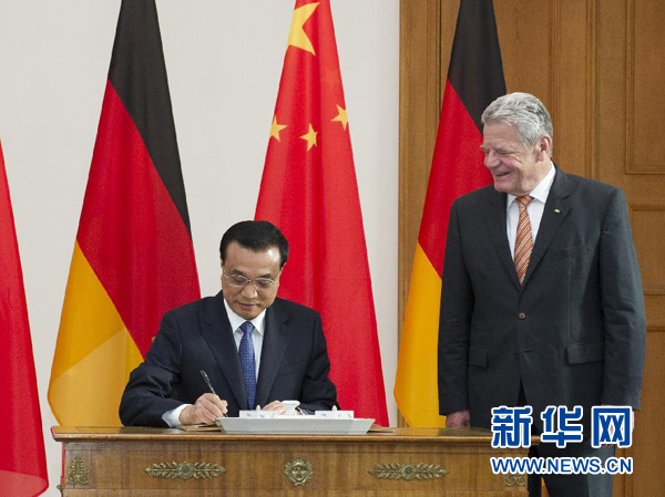 10月10日，國務(wù)院總理李克強在柏林會見德國總統(tǒng)高克。這是李克強總理在高克總統(tǒng)的陪同下在貴賓簿上簽字。 新華社記者 王曄 攝 