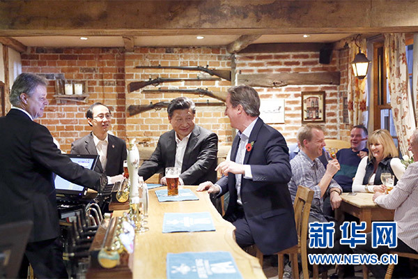 這是會晤結(jié)束后，習近平在卡梅倫陪同下乘車前往當?shù)匦℃?zhèn)體驗酒吧文化。新華社記者 鞠鵬 攝