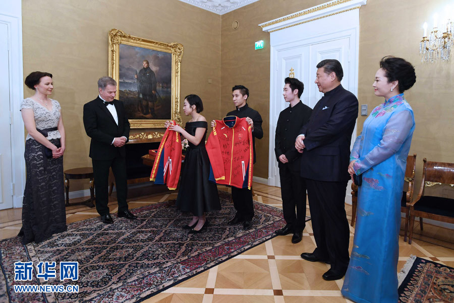 當?shù)貢r間4月5日晚，國家主席習近平和芬蘭總統(tǒng)尼尼斯托在赫爾辛基共同會見剛剛參加完2017年世界花樣滑冰錦標賽的中芬兩國冰雪運動員代表。習近平夫人彭麗媛和尼尼斯托夫人豪吉歐參加會見。這是中國運動員向尼尼斯托和夫人豪吉歐贈送運動衣。新華社記者 饒愛民 攝